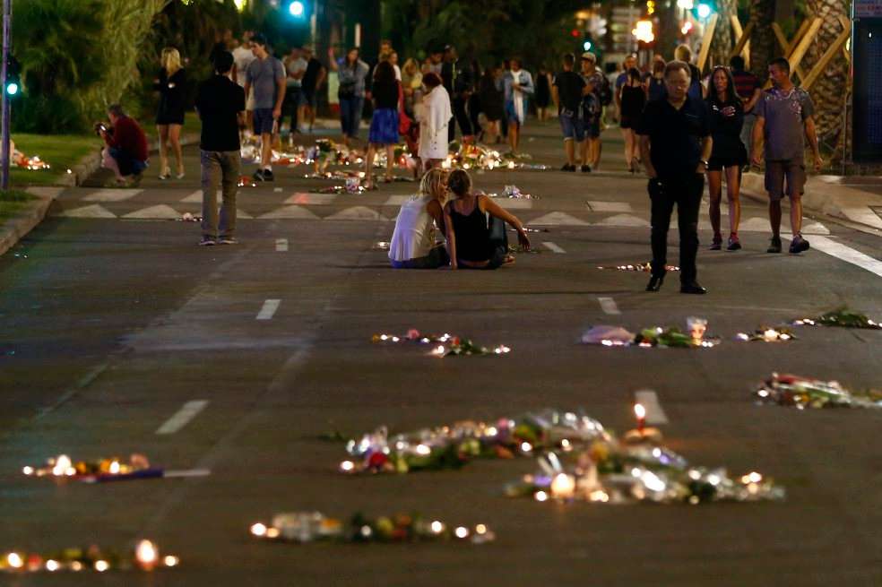 La gente camina y prende velas en la calle de Niza donde un hombre a bordo de un camión arrolló a 84 personas durante la celebración del Día de Francia. / EFE