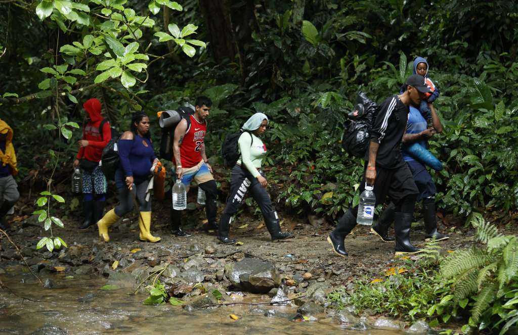 ACOMPAÑA CRÓNICA: CRISIS MIGRATORIA***AME5508. TAPÓN DEL DARIÉN (COLOMBIA), 17/10/2022.- Migrantes caminan el 8 de octubre de 2022 en el Tapón del Daríen (Colombia). Atravesar los ríos y caminos enlodados del Darién a ritmo de Ozuna, así ha contado Marlon Anaya en sus redes sociales los siete días de travesía por una de las selvas más peligrosas del mundo rumbo al llamado "sueño americano". "Madre, bendición, yo sé que me mandó a comprar el kilo de pollo para el almuerzo, pero sin querer terminé por aquí en el Darién", dice Anaya (@marlon23jr), mientras sujeta el celular con una mano y trata de sacar los pies del lodo para seguir avanzando. EFE/Mauricio Dueñas Castañeda