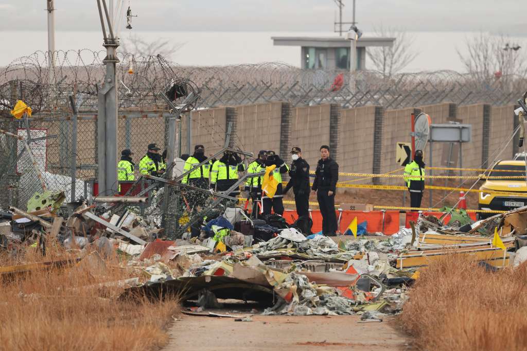 Muan (Republic Of Korea), 29/12/2024.- Police officials gather to conduct search operations around the wreckage site of the Jeju Air aircraft at Muan International Airport in Muan, South Korea, 30 December 2024. According to the South Korea National Fire Agency (NFA), a passenger jet carrying 181 people erupted in flames after going off the runway at an airport in South Korea's southwestern county of Muan on 29 December, leaving 179 people dead as two crew members survived. (Corea del Sur) EFE/EPA/HAN MYUNG-GU