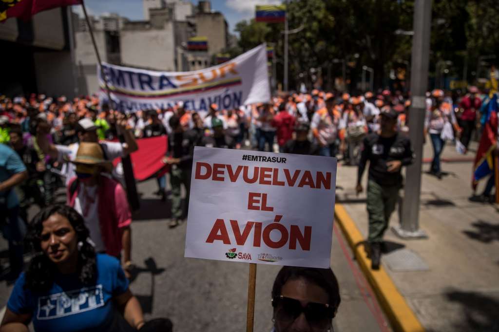 AME8443. CARACAS (VENEZUELA), 09/08/2022.- Decenas de personas se manifiestan pidiendo la recuperación del avión venezolano-iraní que se encuentra retenido en Argentina desde junio pasado, así como para la liberación de su tripulación hoy, en Caracas (Venezuela). EFE/ Miguel Gutiérrez