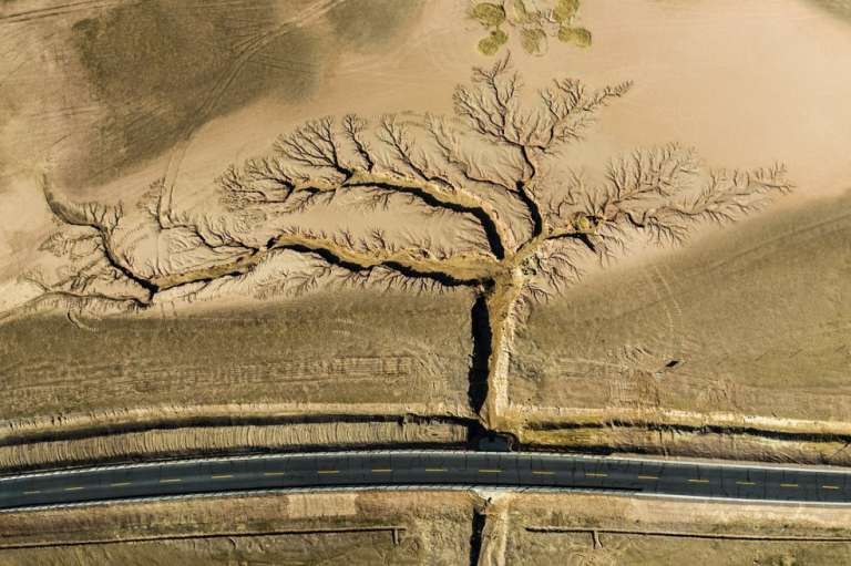 La fotografía del año fue tomada por Li Ping, de China. Para conseguir esta fotografía, Ping durmió en un estacionamiento al borde de la carretera durante la noche. Poco después del amanecer, envió un dron para inmortalizar el camino vacío y los barrancos ramificados, que fueron creados por la erosión del agua de lluvia.