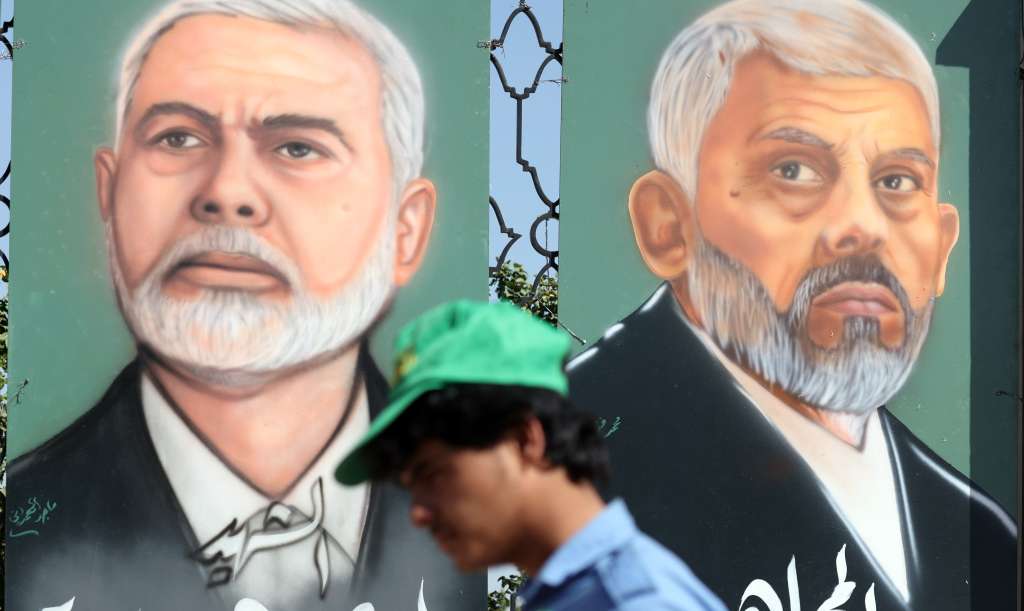 Sana'a (Yemen), 18/10/2024.- A Houthi supporter passes paintings depicting the two late Hamas leaders Yahya Sinwar (R) and Ismail Haniyeh (L) on display during a rally in solidarity with the Lebanese and Palestinian people in Sana'a, Yemen, 18 October 2024. The Israeli Army, Tsahal, on 17 October 2024 confirmed that Hamas leader Yahya Sinwar was 'eliminated' on 16 October 'after a year-long pursuit'. Thousands of people participated in the rally in solidarity with the Lebanese and Palestinian people and to condemn the US support for Israel's military operations in Lebanon and the Gaza Strip, amid high tensions in the Middle East. (Protestas, Líbano) EFE/EPA/YAHYA ARHAB