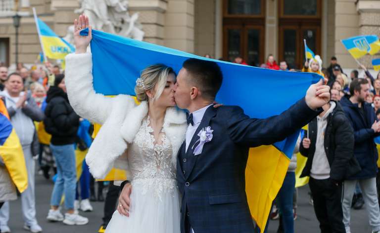 Odesa (Ukraine), 12/11/2022.- A wedding couple kiss as they celebrate together with Ukrainians who lived in Kherson and left it due to the Russian occupation in downtown of the South Ukrainian city of Odesa, 12 November 2022. Ukrainian troops came into Kherson on 11 November to continue to retake the South of Ukraine from Russian troops. Russian troops entered Ukraine on 24 February 2022 starting a conflict that has provoked destruction and a humanitarian crisis. (Rusia, Ucrania) EFE/EPA/STR