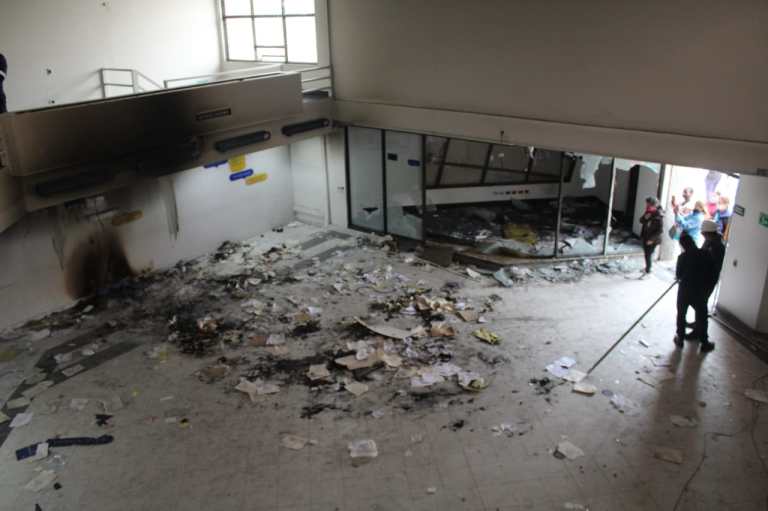 Comerciantes limpian los escombros que dejaron los actos vandálicos durante la noche del "4M" en el sur de Bogotá.
