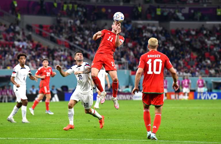 Doha (Qatar), 21/11/2022.- Gareth Bale (C) of Wales heads the ball in front of Christian Pulisic of the USA during the FIFA World Cup 2022 group B soccer match between the USA and Wales at Ahmad bin Ali Stadium in Doha, Qatar, 21 November 2022. (Mundial de Fútbol, Estados Unidos, Catar) EFE/EPA/Neil Hall