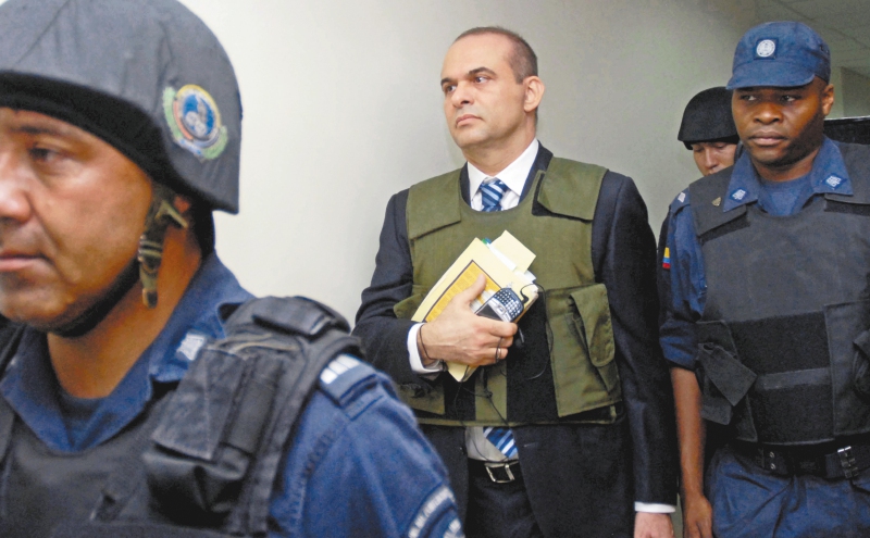 Former far-right paramilitary leader Salvatore Mancuso is escorted by guards to a court in Medellin, Colombia, Tuesday, May 15, 2007. Under a peace deal with the government, Mancuso and other members of the United Self-Defense Forces of Colombia, AUC, must give detailed confessions of their alleged participation in crimes and atrocities. (AP Photo/ Luis Benavides, Pool)