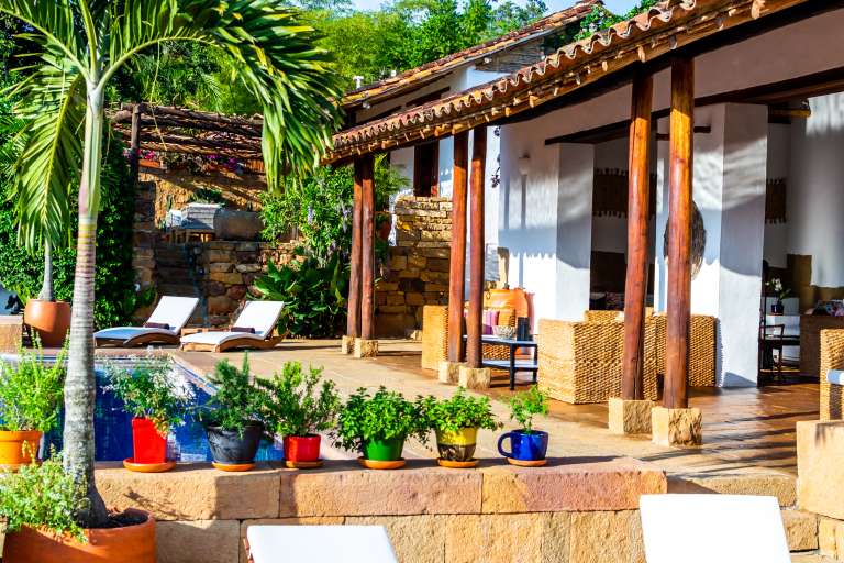 Imagen de un hotel con piscina, palmeras y plantas.