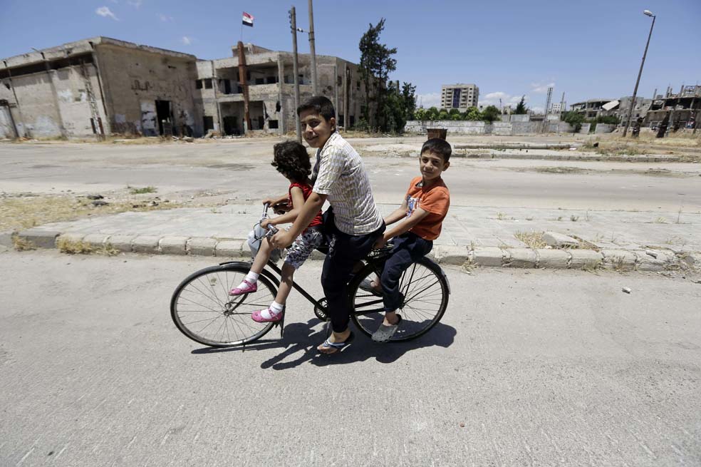 Niños sirios en el vencindario Bab Amr en Homs, una de las ciudades más destruídas por los bombardeos del ejército sirio. / AFP