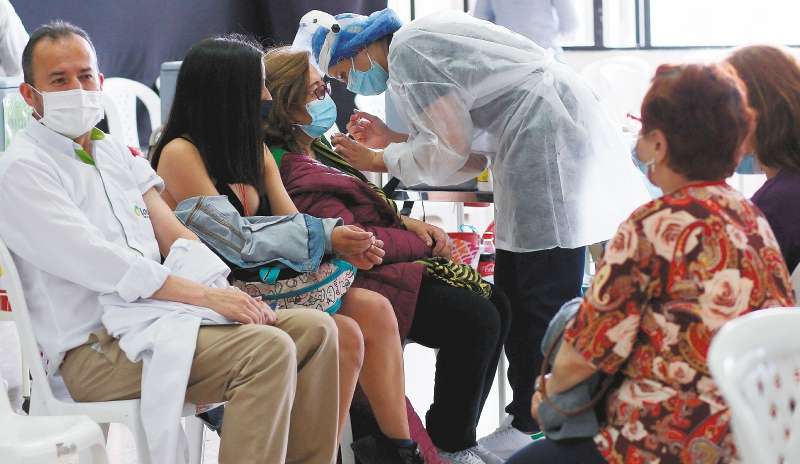 Los y las colombianas deberán seguir usando el tapabocas en
espacios cerrados como centros de salud, hogares geriátricos y transporte público. / AFP