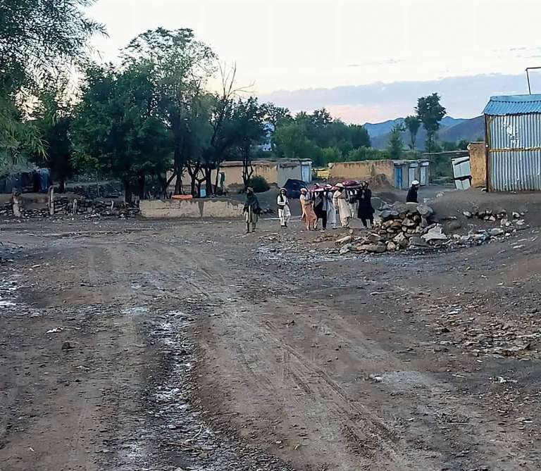 Personas cargando a los heridos tras un terremoto en el distrito de Gayan.