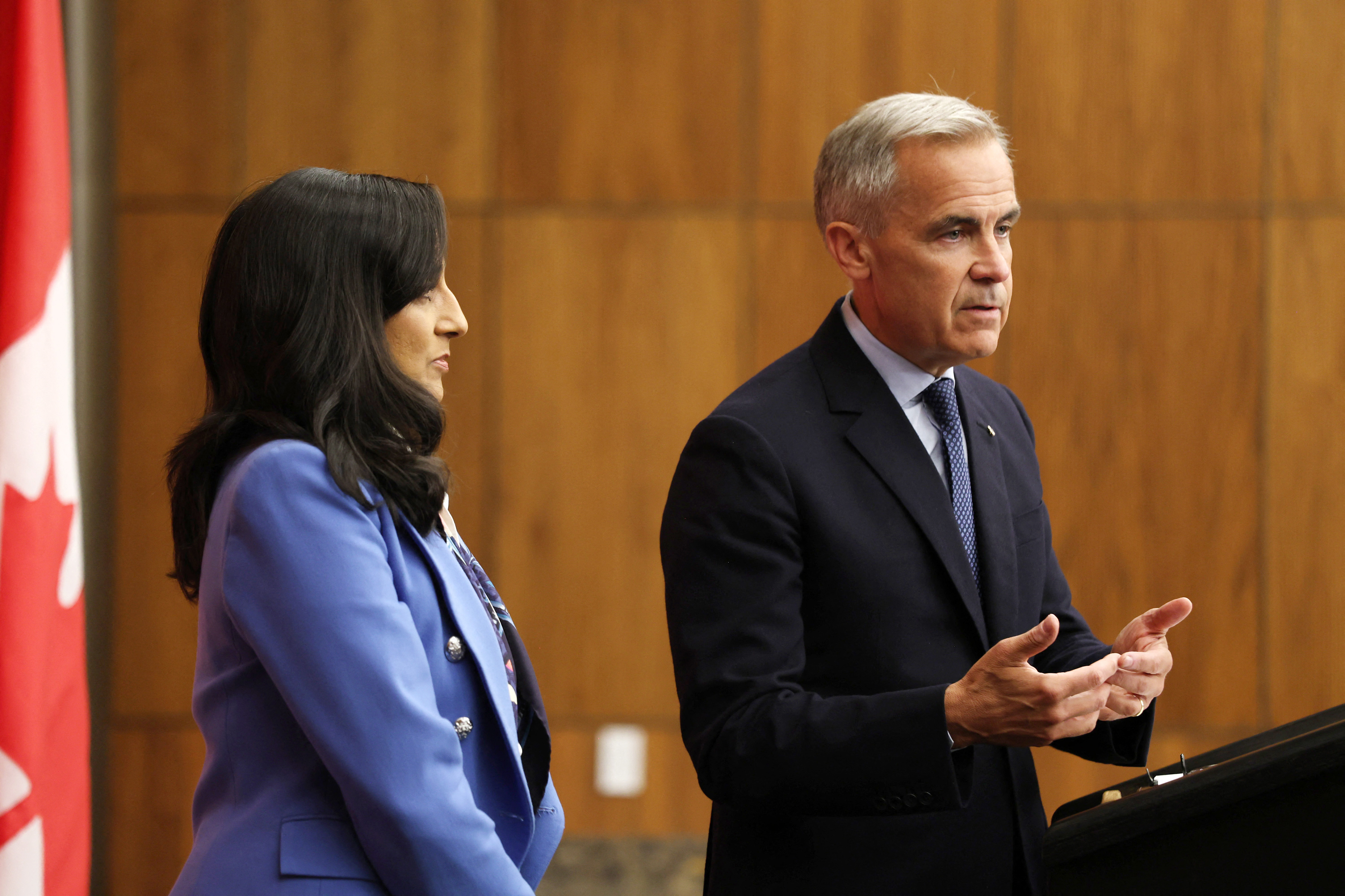 Canadian Prime Minister Mark Carney (R), flanked by Canadian Foreign Affairs Minister Anita Anand, speaks during a press conference after a Cabinet meeting to discuss both trade negotiations with the US and the situation in the Middle East, at the National Press Theatre in Ottawa, Ontario, Canada on July 30, 2025.