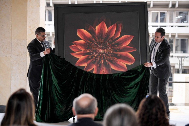 El poeta Jorge Alejandro Medellín, hijo del magistrado Carlos Medellín asesinado en la toma, expuso su obra titulada ‘Gracias a la vida’: Una pintura de una flor en el que en su centro reposa una imagen de la quema del palacio de Justicia.