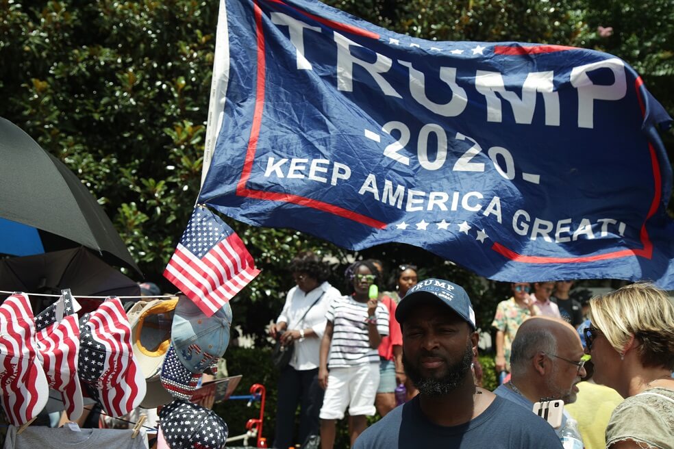 Un vendedor ambulante vende mercancía de la campaña de Trump durante el evento del 4 de julio.  / AFP