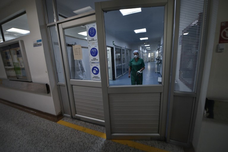 Una mujer que camina por un pasillo y se acerca a una puerta