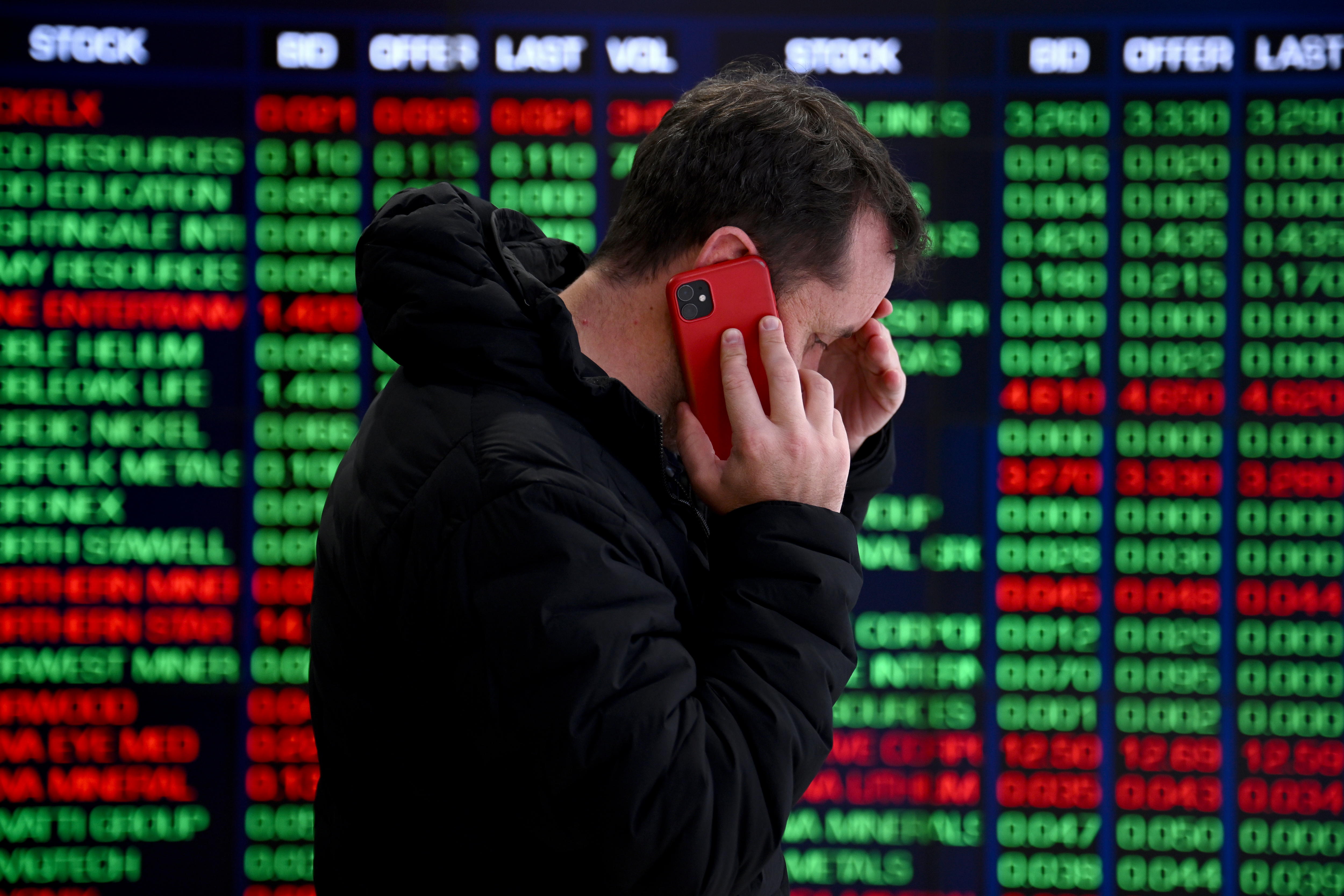 Sídney (Australia), 05/08/2024.- Una persona habla por teléfono frente a los paneles indicadores en la Bolsa de Valores de Australia (ASX) en Sídney, Australia, este lunes. La ASX se ha desplomado por temor a una recesión en EE.UU., cotizando en su nivel más bajo desde 2022. EFE/ Bianca De Marchi AUSTRALIA AND NEW ZEALAND OUT
