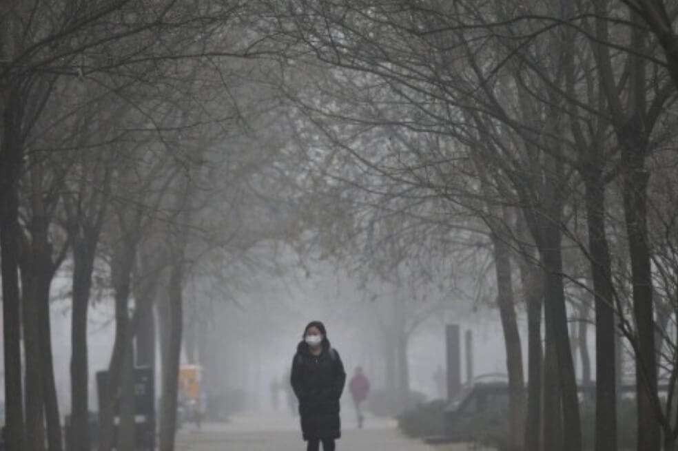 Una mujer camina con una mascara debido a la contaminación en Pekín. / EFE/Wu Hong