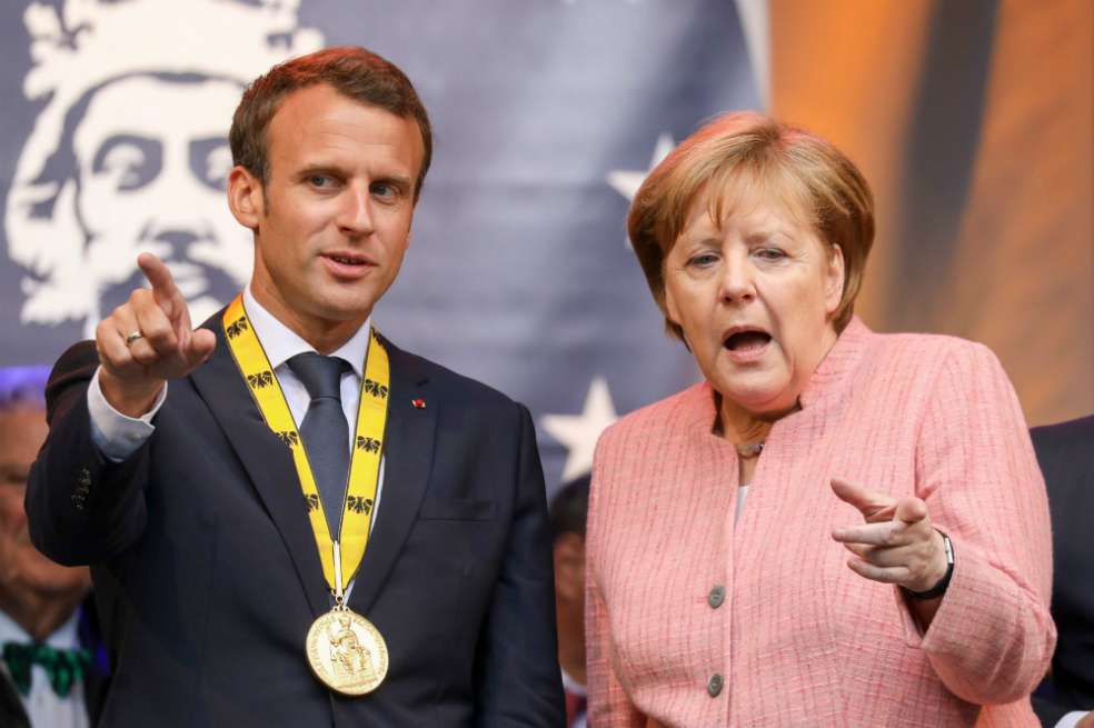 El presidente francés Emmanuel Macron y la canciller alemana Angela Merkel durante la ceremonia del premio Carlomagno. / AFP
