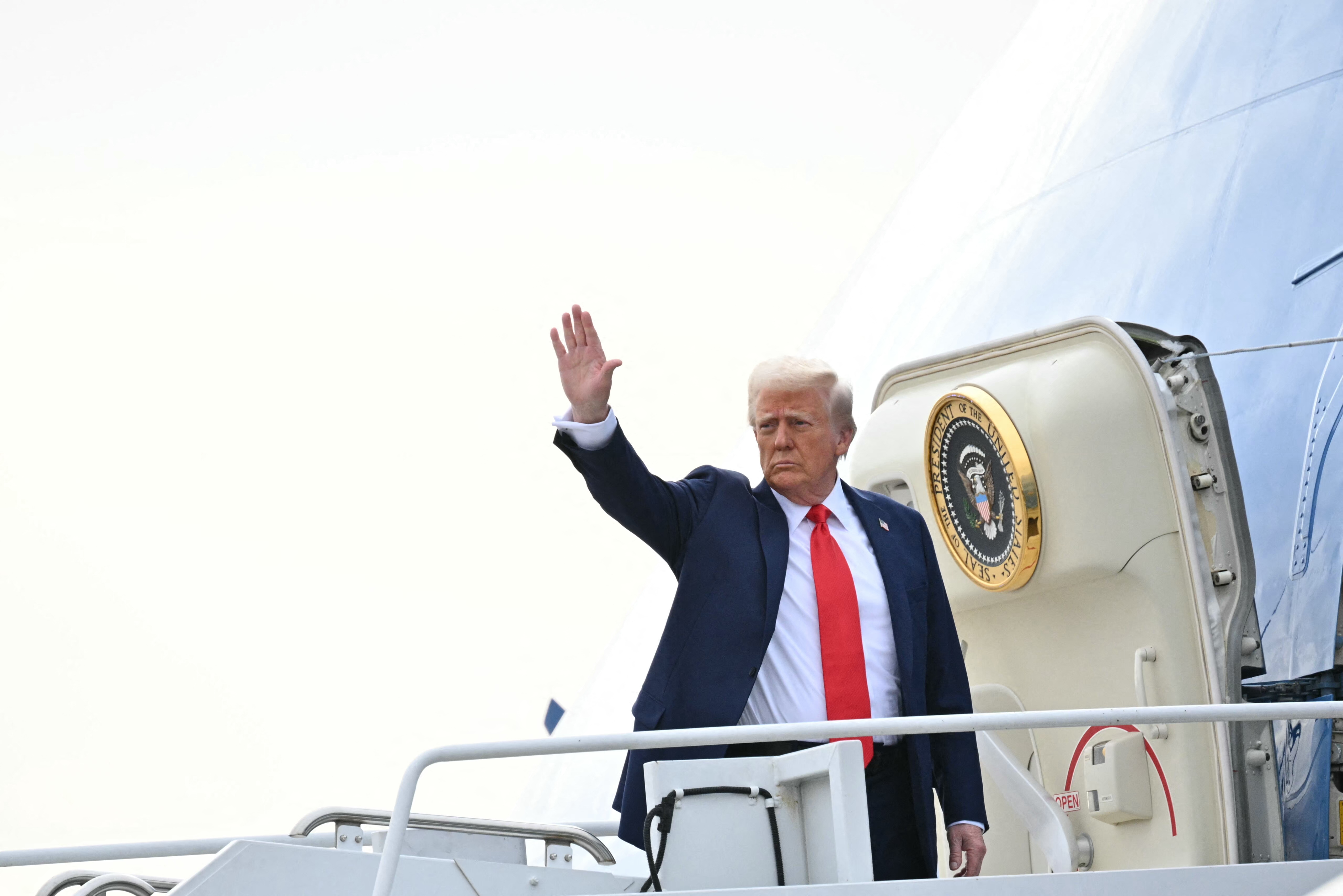 US President Donald Trump waves as he boards Air Force One upon departure from Harry Reid International Airport in Las Vegas, Nevada on January 25, 2025.