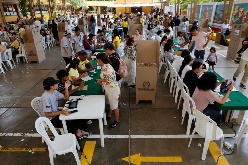 AME2985. BARRANQUILLA (COLOMBIA), 21/06/2026.- Personas asisten a votar durante la segunda vuelta de las elecciones presidenciales este domingo, en Barranquilla (Colombia). La elección del sucesor del presidente colombiano, Gustavo Petro, avanza sin incidentes, en una jornada en la que el candidato de ultraderecha Abelardo de la Espriella y el izquierdista Iván Cepeda ya votaron y llamaron a los indecisos a apoyarlos para ganar. EFE/ Mauricio Dueñas Castañeda