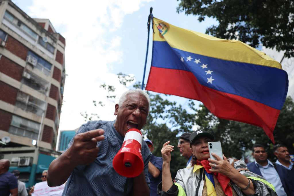 FOTODELDÍA AME8402. CARACAS (VENEZUELA), 12/08/2026.- Personas participan en una manifestación para pedir salarios dignos y mejoras laborales este miércoles, mientras la primera ronda de negociación entre el Gobierno y la oposición de Venezuela, promovida por Estados Unidos, ocurre al interior del hotel Meliá Caracas, en Caracas (Venezuela). EFE/ Miguel Gutiérrez