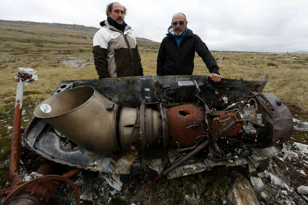 Gustavo Giménez (izq) y Eduardo Mirabetto posan ante los restos de un helicóptero argentino, a las afueras de Puerto Stanley.  / EFE