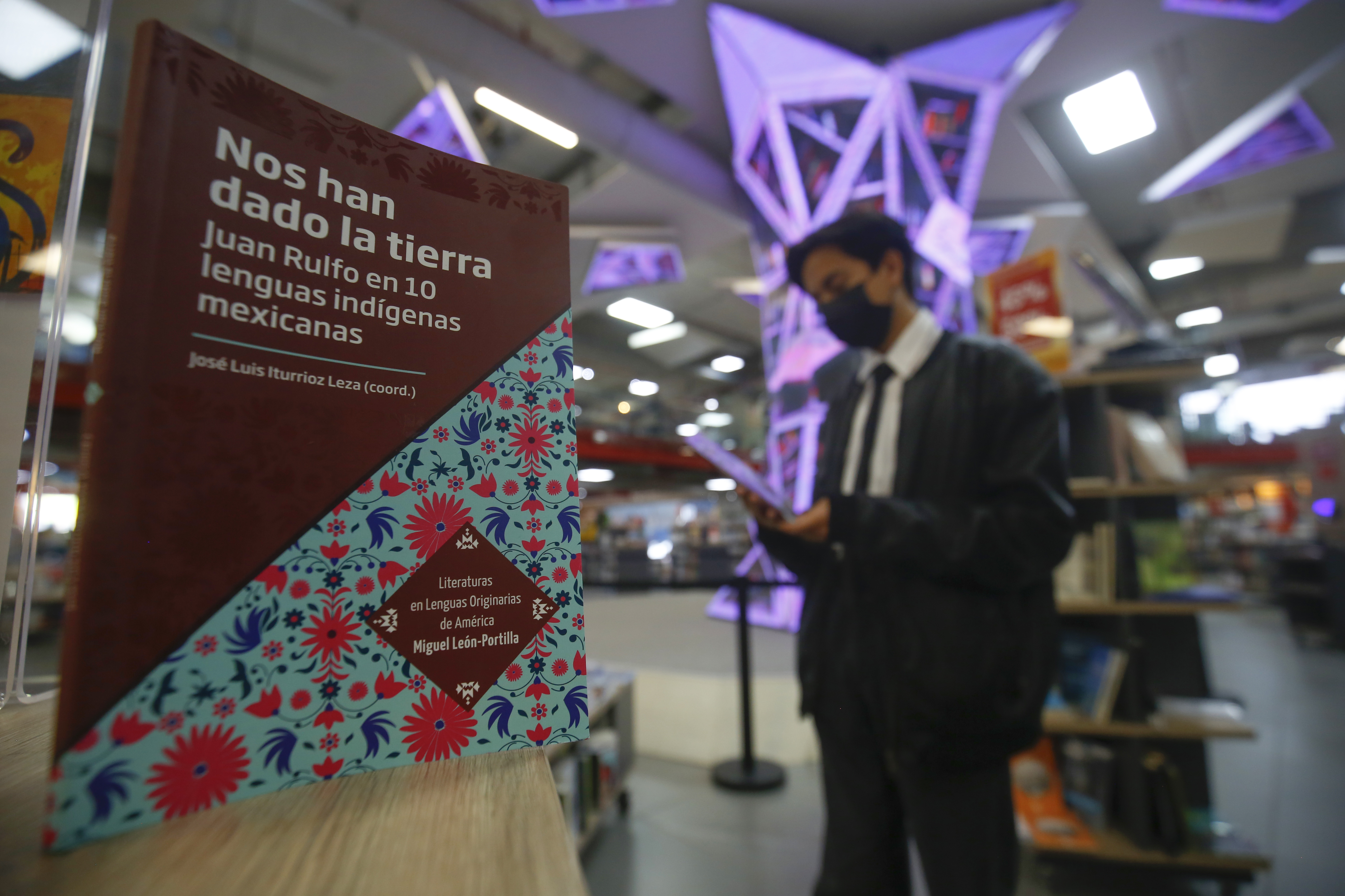 MEX8624. GUADALAJARA (MÉXICO), 16/07/2022.- Una persona observa el libro "Nos han dado la Tierra" del autor José Luis Iturrioz, exhibido en una librería en la ciudad de Guadalajara, en Jalisco (México). Por primera vez en la historia, una editorial tradujo un cuento del célebre escritor mexicano Juan Rulfo, “Nos han dado la tierra”, a 10 lenguas indígenas en un libro que busca acercar la literatura en español a las comunidades originarias. El compilador del libro, José Luis Iturrioz, dice este sábado a Efe que la publicación es un intento para que la obra rulfiana también esté al alcance de quienes hablan lenguas originarias, pues desde hace años ha sido traducida a otros idiomas, pero se había dejado de lado a los lectores de estas comunidades. EFE/ Francisco Guasco