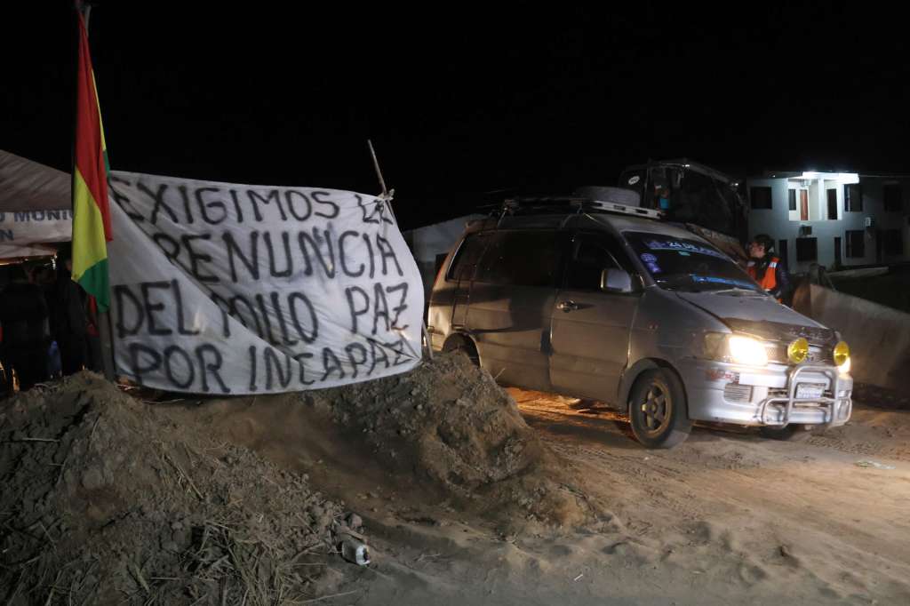 AME2808. SAN JULIAN (BOLIVIA), 21/06/2026.- Vehículos transitan por una vía tras el desbloqueo por parte de la Policía de Bolivia este domingo, en San Julián (Bolivia). El Legislativo de Bolivia validó el decreto presidencial que declaró el estado de excepción para levantar los bloqueos de carreteras instalados a principios de mayo por sectores campesinos y seguidores del exmandatario Evo Morales que exigen la renuncia del presidente Rodrigo Paz. EFE/ Juan Carlos Torrejón