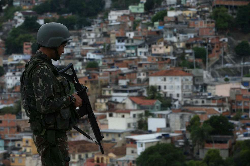 Un soldado del ejército brasileño patrulla una localidad en la favela da "Mineira" en Río de Janeiro (Brasil). / EFE, Marcelo Sayão