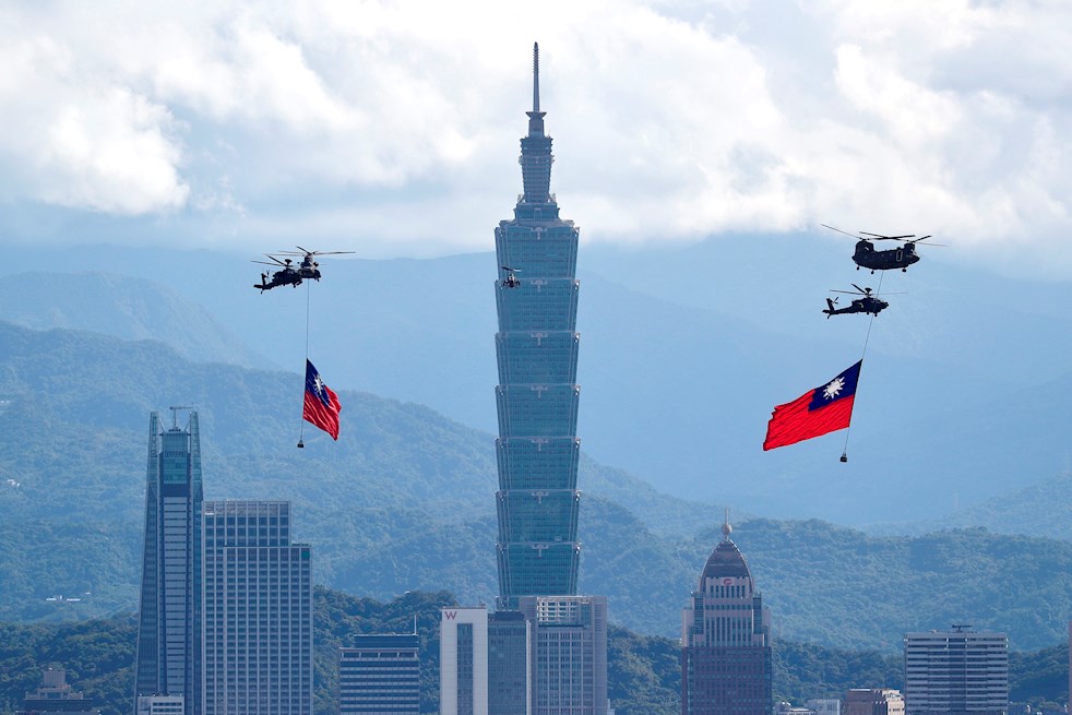 Helicópteros izan banderas gigantes de Taiwán mientras vuelan cerca de la torre 'Taipei 101' en el centro de Taipei durante un ensayo de sobrevuelo de la bandera de Taiwán antes del Día Nacional del país en Taipei.