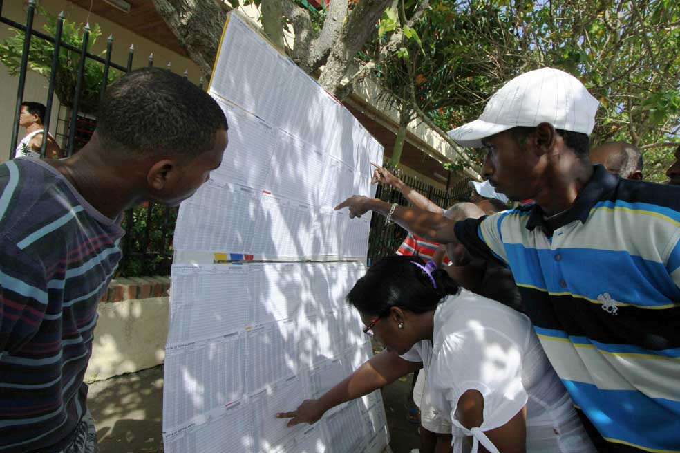 Electores buscan la mesa donde les toca votar en un puesto de votación en zonas rurales de Colombia