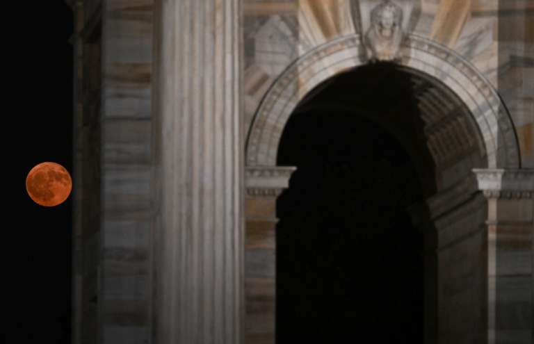 La luna llena, conocida como la «Luna de fresa», se eleva detrás del Arco della Pace («Arco de la Paz») en Milán, el 11 de junio de 2025.