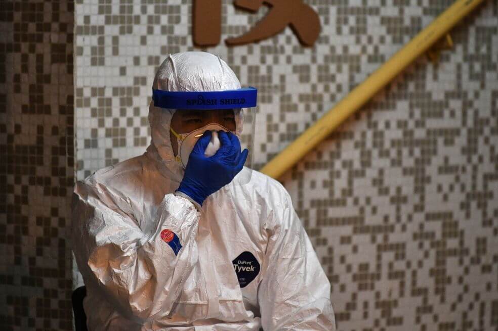 Personal médico revisa su máscara mientras espera cerca de una propiedad residencial en Hong Kong, después de que se confirmó que dos personas en el lugar habían contraído el coronavirus según informes de periódicos locales.
/ Anthony Wallace/ AFP