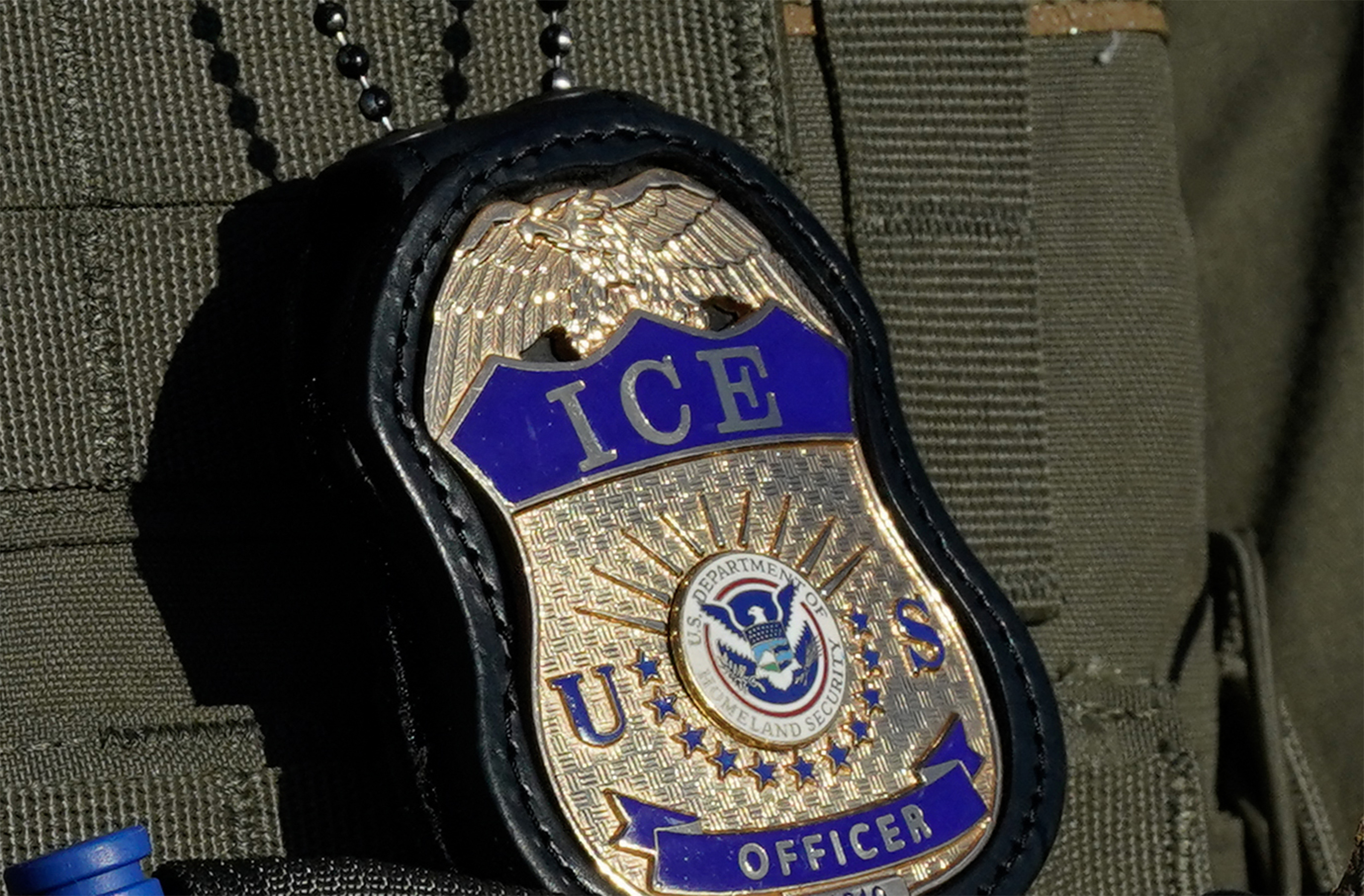 (FILES) A detail view of a badge work by an Immigration and Customs Enforcement (ICE) agent near a gate at Delaney Hall, a newly converted immigrant detention centre in Elizabeth, New Jersey May 7, 2025.