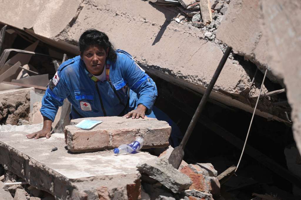 AME7690. CALI (COLOMBIA), 10/08/2026.- Una integrante de la Cruz Roja de Colombia busca entre los escombros de una edificación colapsada por el terremoto de magnitud 7,4 que sacudió al país, este lunes en Cali (Colombia). EFE/ Ernesto Guzmán Jr