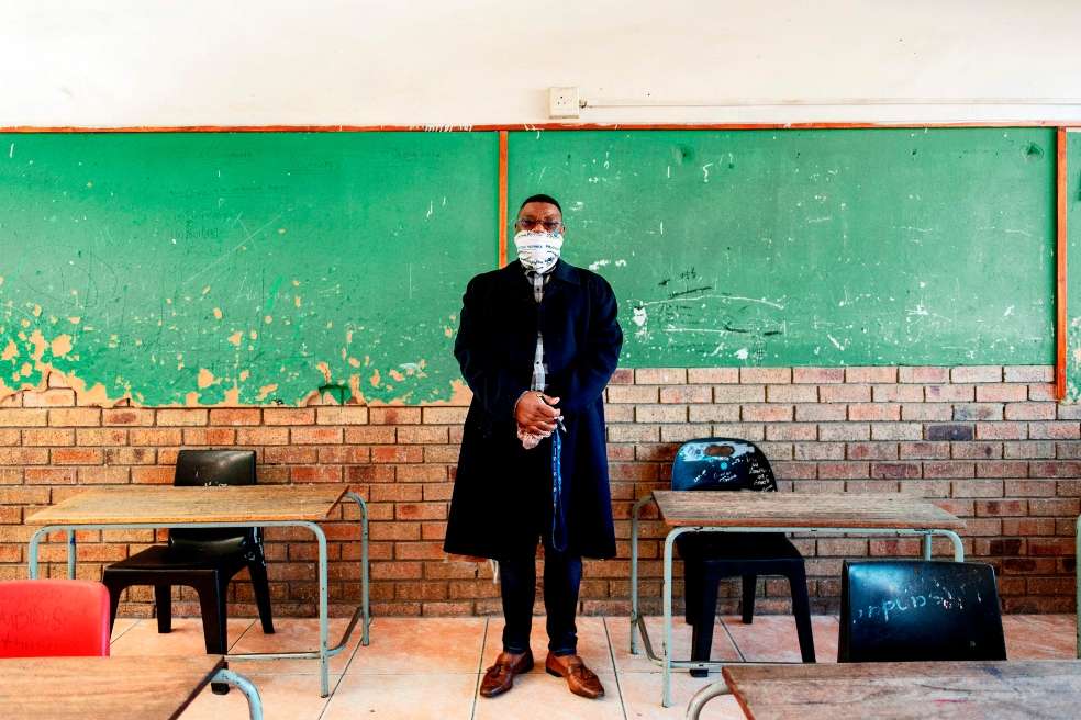 Un profesor sudafricano posa en su salón de clase, el día en que el gobierno pasó de la fase 3 de confinamiento y un Tribunal le pide revisar las medidas.