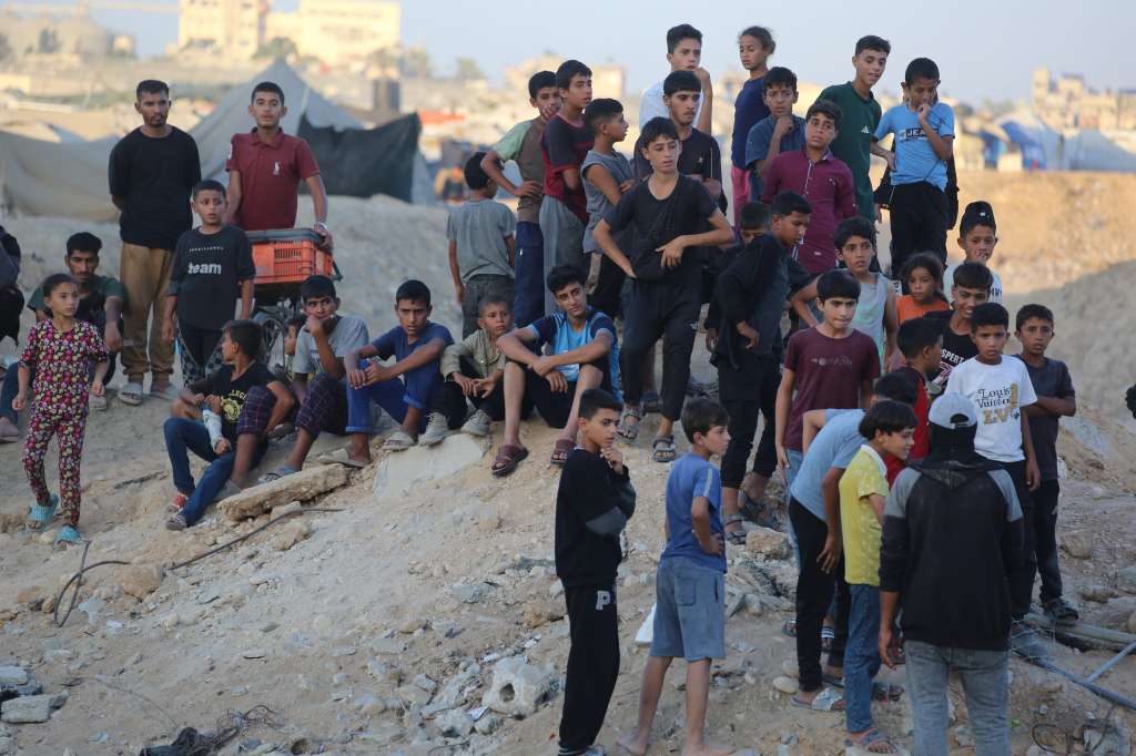 People stand near a tunnel in an area north of Khan Yunis in the southern Gaza Strip on October 28, 2025, as Hamas militants search for bodies. Israel's military on October 28 accused Hamas of staging its search for the remains of a Gaza hostage body, one of 28 the group had agreed to hand over under a ceasefire deal. Hamas says it is committed to the ceasefire terms, but lacks the equipment needed to locate and excavate hostage bodies potentially buried under buildings collapsed by air strikes. (Photo by Bashar TALEB / AFP)