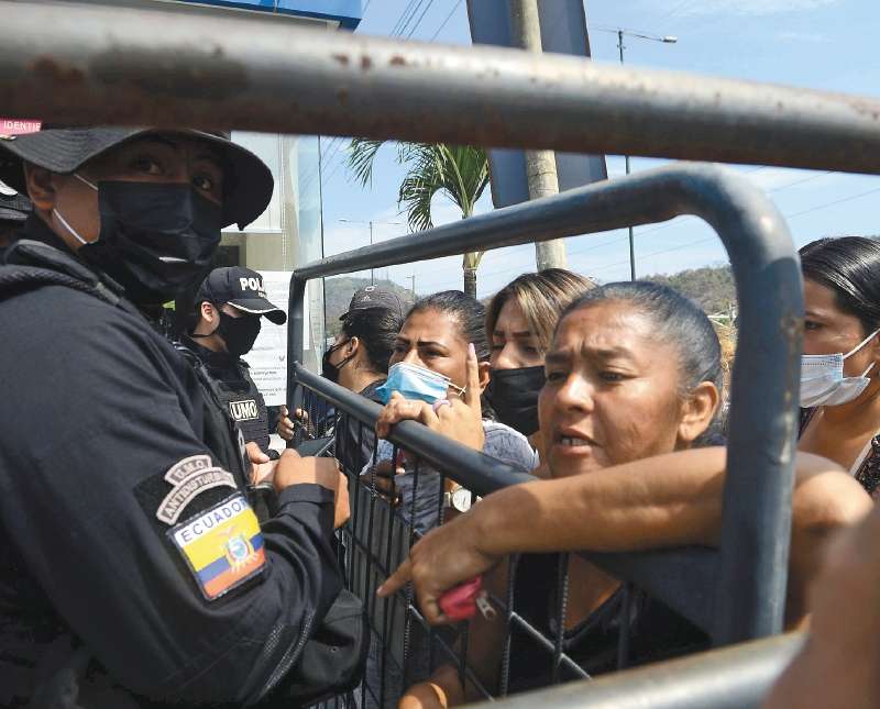 Relatives of inmates of the Litoral penitentiary wait for information about the fate of their loved ones after a deadly riot at the prison, outside the morgue in Guayaquil, Ecuador, Thursday, Sept. 30, 2021. (AP Photo/Jose Sanchez)