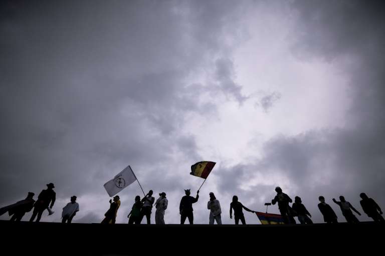 Manifestantes ondean banderas encima de la estación Ciudad Universitaria, sobre la calle 26.