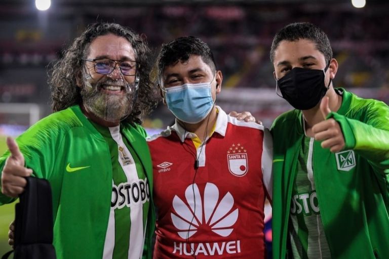 Por un momento, lo que importó sí fue el fútbol y el regreso a la vida. En la fotografía se pueden ver dos hinchas de Nacional y uno de Santa Fe, conviviendo en paz al rededor de la pelota, no de una guerra.