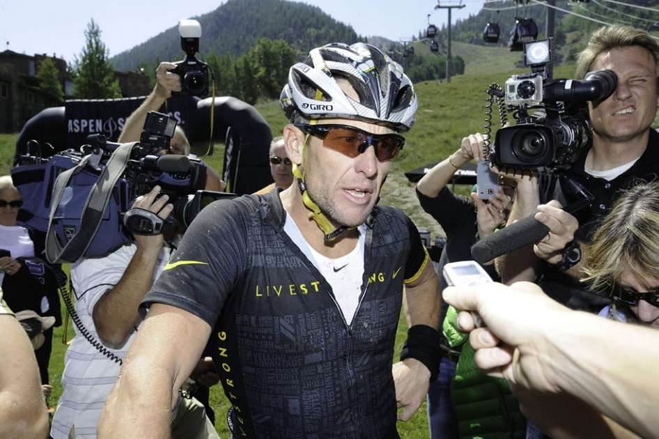 Lance Armstrong habla con la prensa, luego de competir en una prueba aficionada de ciclomontañismo. / AFP
