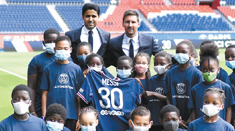 Messi posa con niños de la fundación PSG y con Nasser Al-Khelaïfi, presidente del club. / AFP