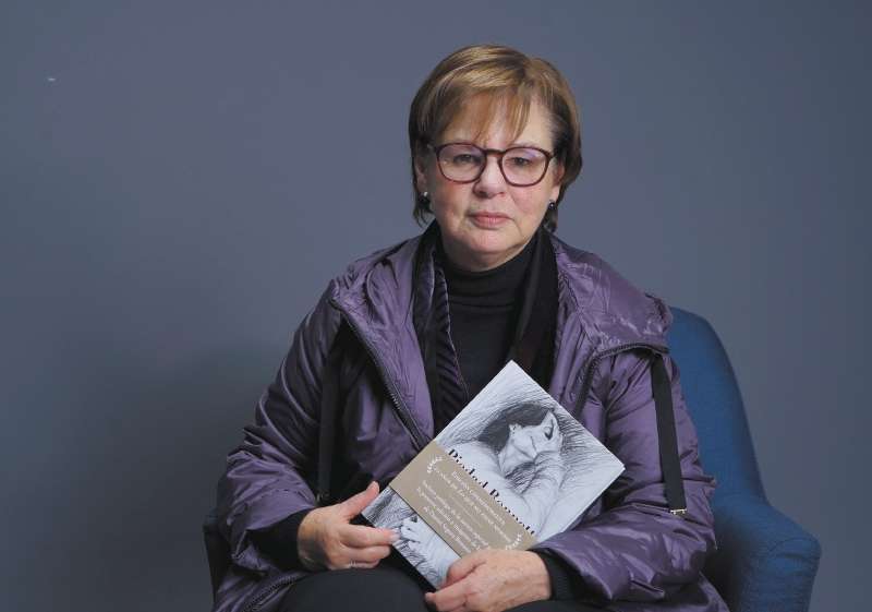 Piedad Bonnett con el libro conmemorativo de "Lo que no tiene nombre" (sello editorial Alfaguara), sobre el suicidio de su hijo Daniel. La portada es un autorretrato de él cuando tenía 18 años de edad. / Foto: Richard León