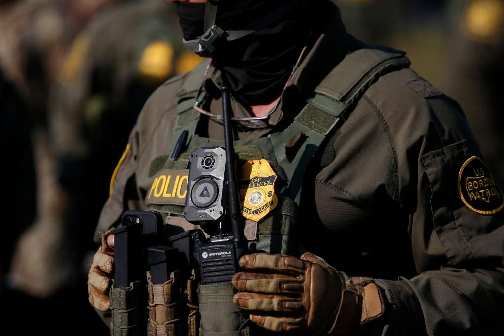 A US Customs and Border Protection (CBP) agent stands guard as hundreds of protesters gather near an Immigration and Customs Enforcement (ICE) facility opposing the detention of undocumented immigrants following President Donald Trump�s order t
