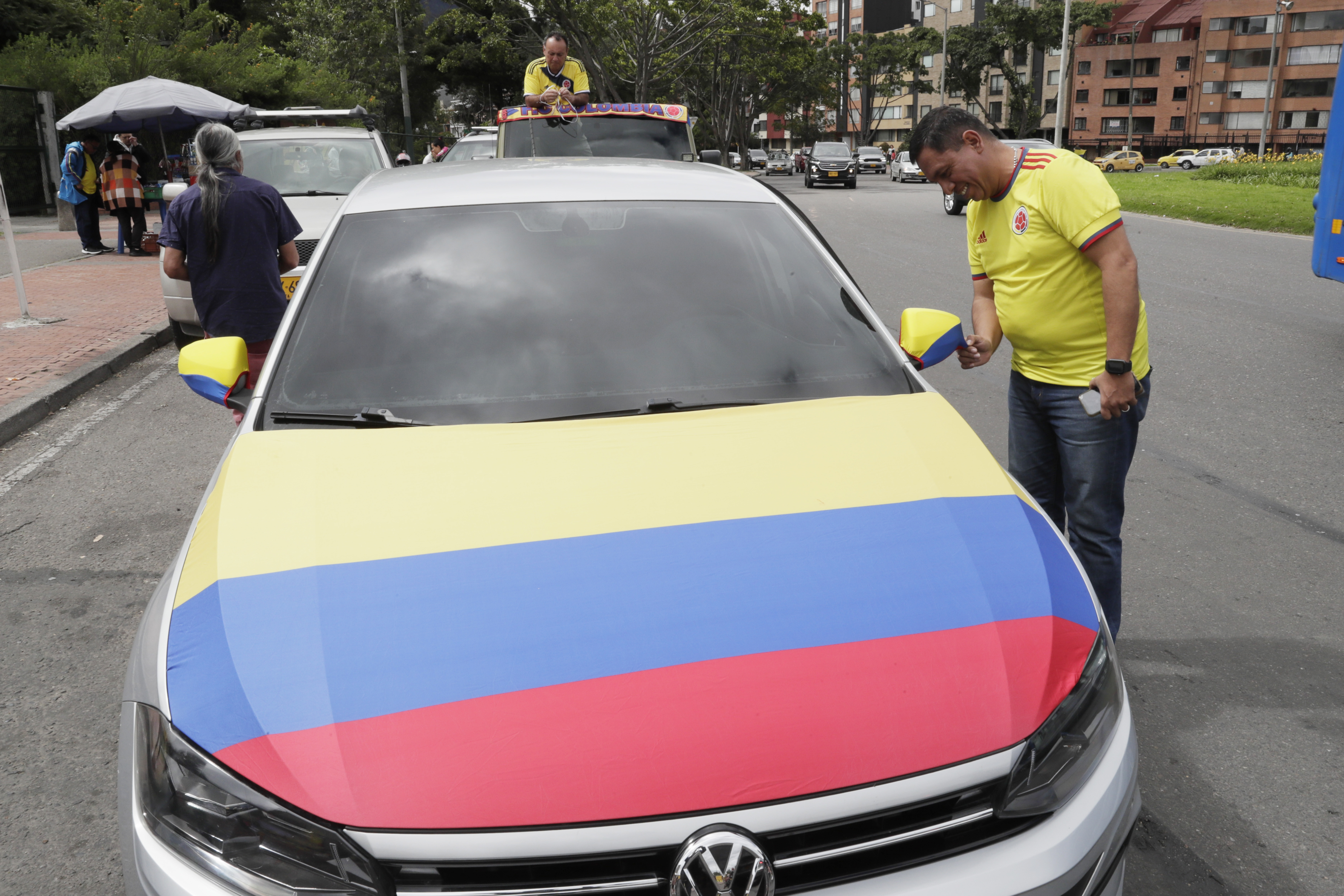 AME1805. BOGOTÁ (COLOMBIA), 14/07/2024.- Un aficionado de la selección colombiana de fútbol adorna su carro con la bandera de Colombia, este domingo Bogotá (Colombia). Los colombianos amanecieron este domingo envueltos en su bandera e ilusionados con la posibilidad de que su selección de fútbol derrote a Argentina en la final de la Copa América y regrese al país desde Miami con el trofeo en el equipaje. EFE/ Carlos Ortega