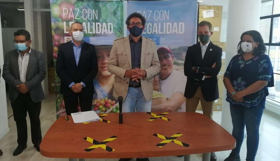 Cinco personas se encuentran de pie, en medio de la firma de seis compromisos