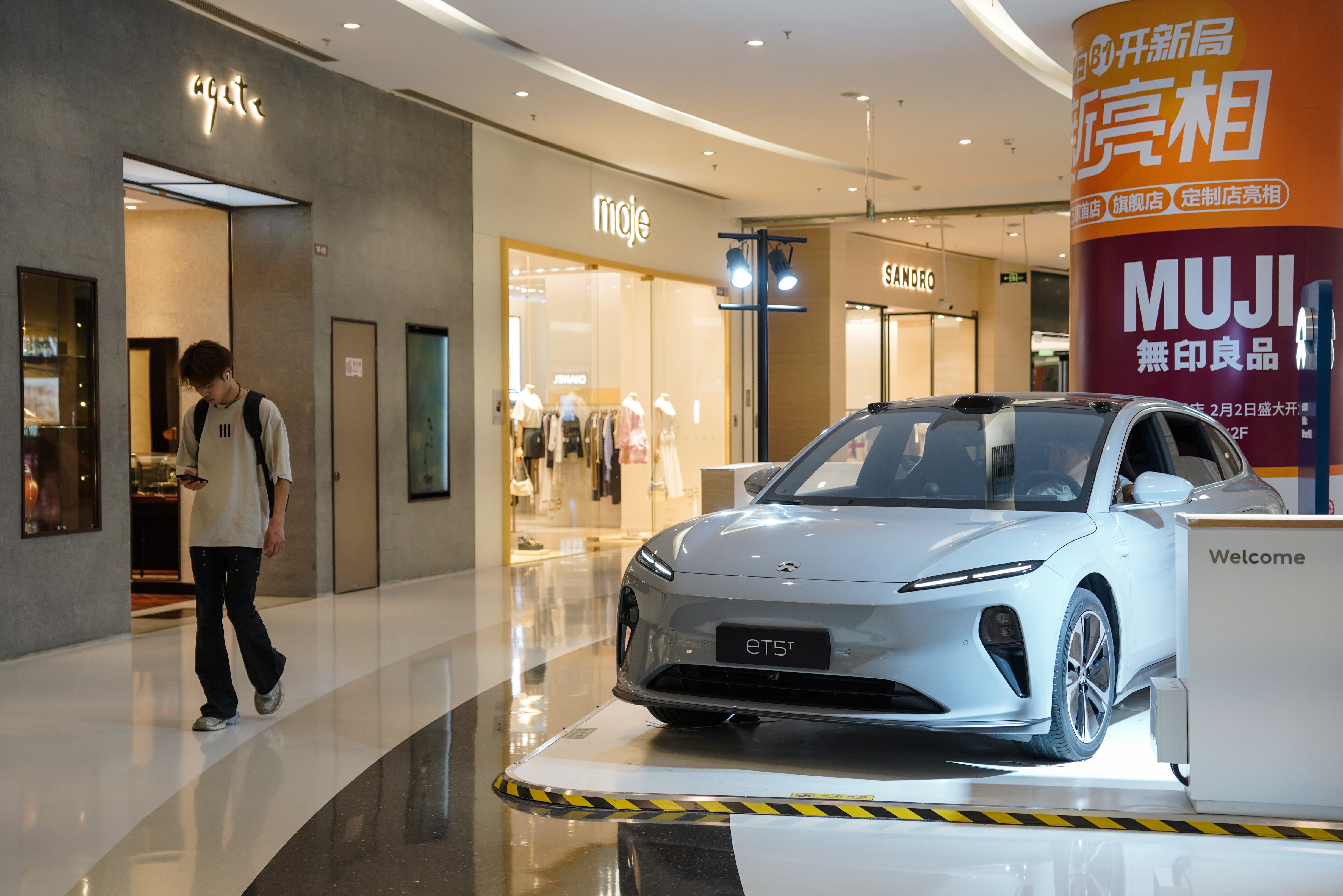 Beijing (China), 13/06/2024.- A man walks beside a NIO ET5 electric car on display in a shopping mall in Beijing, China, 13 June 2024. Beijing urges the European Union to reconsider tariffs on Chinese electric vehicles and to stop going further in what they say is the 'wrong direction' to protect its auto industry from competition, according to China's state news agency Xinhua. China said it would take measures to safeguard its interests after the European Commission announced on 12 June it would impose extra duties of up to 38.1 percent on imported Chinese electric vehicles from July 2024. EFE/EPA/WU HAO