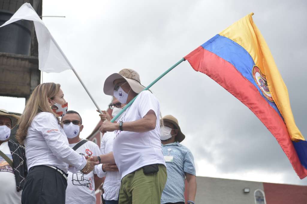Víctima de las “pescas milagrosas" y Pastor Alape, excomandante de las FARC, durante el acto de perdón y reconciliación por las pescas milagrosas y secuestros colectivos que se ejecutaron en varias carreteras del país entre 1998 y 2002 (izq-der).