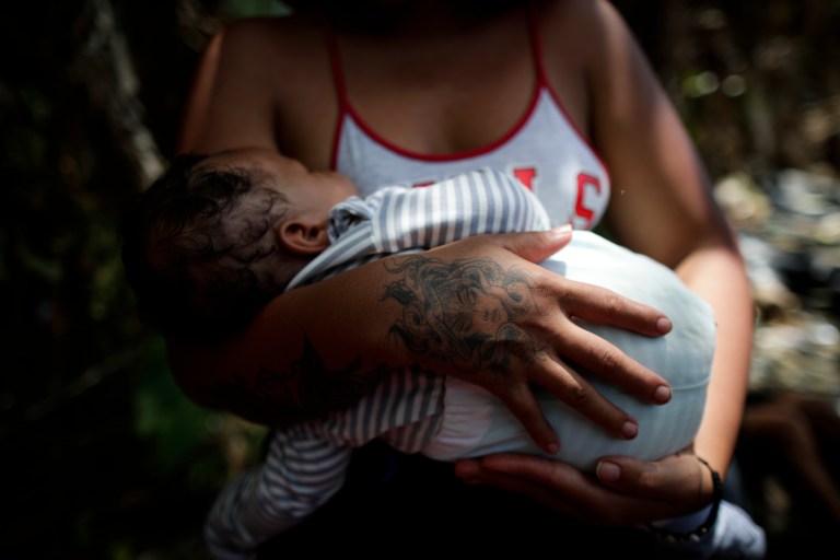 -FOTOGALERÍA- AME4250. BAJO CHIQUITO (PANAMÁ), 21/03/2023.- Ana Teresa Rodríguez, una venezolana de 26 años, carga a su hijo Aquiles Cedeño de 2 meses mientras esperan para ser trasladados en canoa desde la Quebrada León hasta a la comunidad de Bajo Chiquito, el 10 de marzo de 2023, en Darién (Panamá). "Guerreros", repiten las madres, hijos guerreros que han aguantado largas caminatas, hambre, sed, el calor, picaduras de insectos, superar ríos y cerros, para sobrevivir a la selva del Darién en su ruta hacia Estados Unidos. La venezolana Ana Rodríguez también está con su bebé en brazos, que duerme. Durante la selva lo cargó "un ratico" ella, otro su esposo, un amigo. "Hay gente que te ayuda, como hay gente que no tiene fuerza para ayudarte". "Aquí hay mujeres embarazadas, niños, pero no es fácil, lo que se vive adentro no es fácil. Nada más cuando cae la noche, la expectativa de que tus hijos no se enfermen, porque se mojan. Que uno no se enferme, lo que uno ve allá adentro, carpas cerradas con gente adentro muerta. Se ven muchas cosas: travesía, hueco, río hondo, gente ahogándose. Es algo, una experiencia para toda la vida, por una mejoría, porque es la única manera", afirma a EFE Rodríguez. EFE/ Bienvenido Velasco