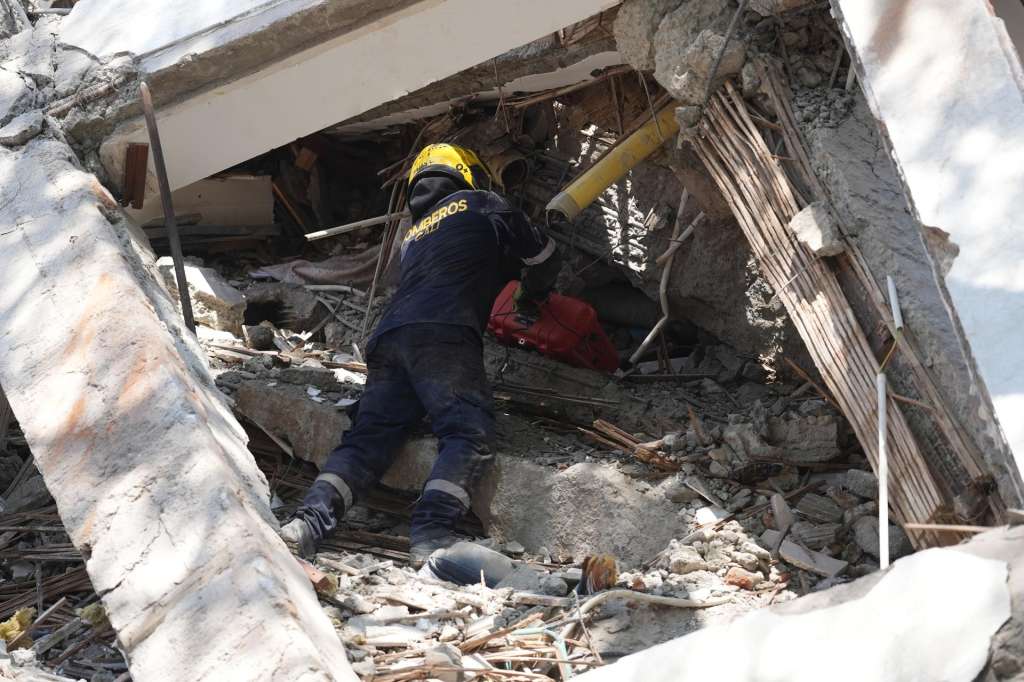AME7686. CALI (COLOMBIA), 10/08/2026.- Un integrante del cuerpo de Bomberos de Cali trabaja entre los escombros de edificaciones colapsadas por el terremoto de magnitud 7,4 que sacudió esta mañana el país, este lunes en Cali (Colombia). Al menos 27 personas murieron en el departamento del Valle del Cauca, lo que eleva a 51 la cifra de fallecidos por el sismo en todo el territorio nacional. EFE/ Ernesto Guzmán Jr