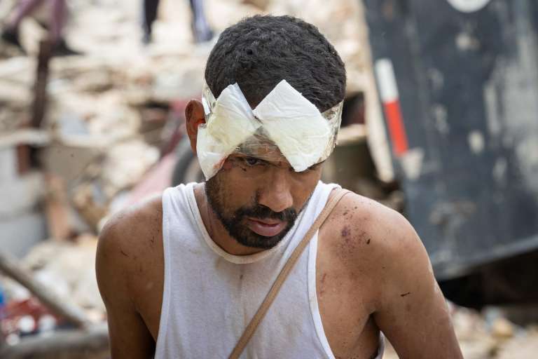 AME4361. LA GUAIRA (VENEZUELA), 25/06/2026.- Una persona herida camina entre los escombros de edificios derrumbados este jueves, en La Guaira (Venezuela). El número de fallecidos en Venezuela a causa de los dos terremotos del miércoles se elevó a 188 y el de heridos a 1.520, mientras que al menos 346 construcciones, entre edificios, hospitales y centros comerciales, resultaron afectadas, informó el presidente de la Asamblea Nacional (AN, Parlamento), el chavista Jorge Rodríguez. EFE/ Ronald Peña R.